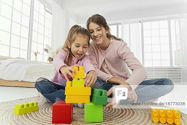 Vorderansicht zwei Schwestern spielen zu Hause Spielzeug. Foto mit hoher Auflösung