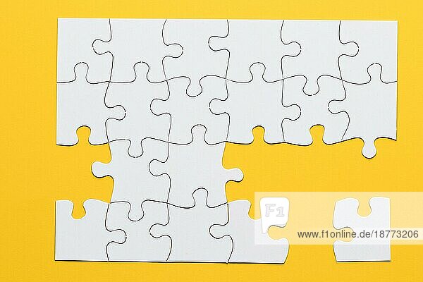 Weißer Karton Puzzlespiele gelben Hintergrund. Hohe Auflösung Foto