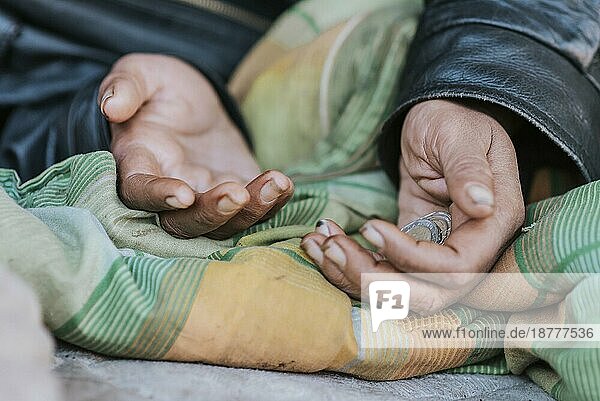 Obdachlose Frau hält die Hände zur Hilfe aus