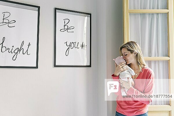 Frau mit Baby hält Rahmen mit Zitaten