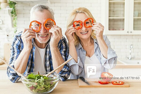 Lächelnd Porträt Senior Paar Blick durch rote Paprika Scheibe