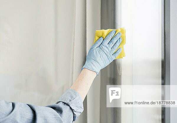 Frau mit Gummihandschuh  die das Fenster wischt. Auflösung und hohe Qualität schönes Foto
