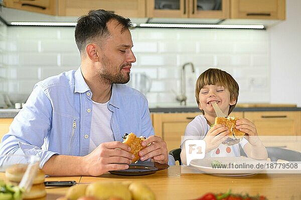 Vater und Sohn essen leckere Burger