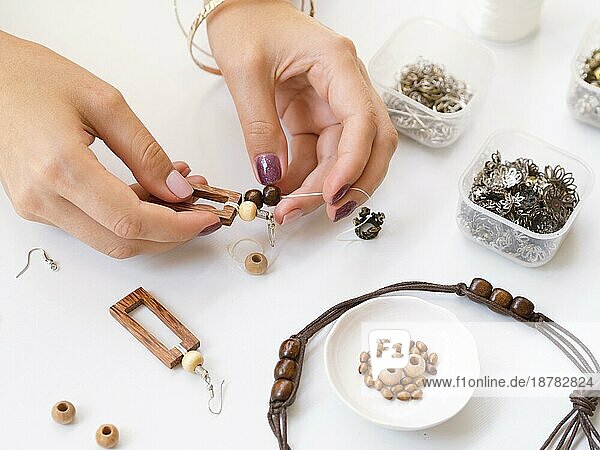 Frau macht Accessoires mit Holzperlen. Auflösung und hohe Qualität schönes Foto