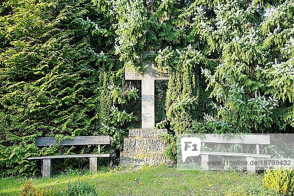 Bank und Heiliges Kreuz auf dem Friedhof im Hamburger Stadtteil Altona. Es ist ein ländlicher  herbstlich gefärbter Friedhof im Norden des Stadtteils. Der Ort lädt zur Ruhe und zur Besinnlichkeit ein