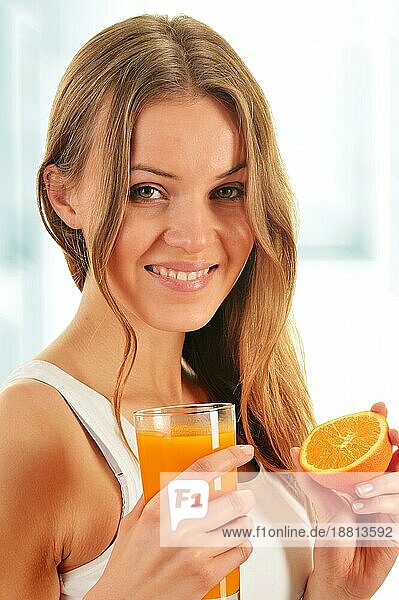 Junge Frau hält ein Glas Orangensaft
