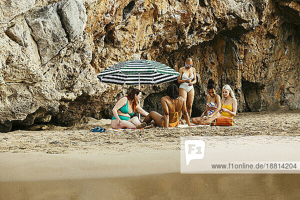 Friends spending leisure time on sand at beach