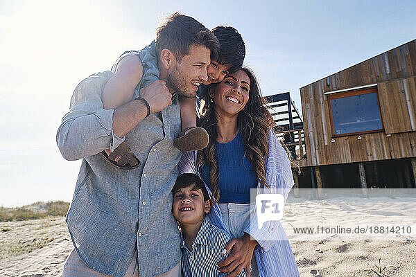 Glückliche Familie  die gemeinsam Spaß vor dem Strandhaus hat