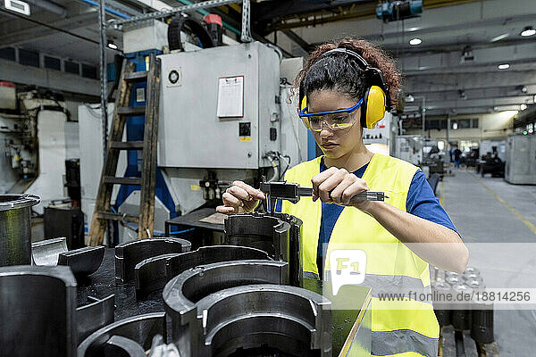 Wartungsingenieur in Arbeitsschutzkleidung führt Qualitätskontrolle in einer modernen Fabrik durch