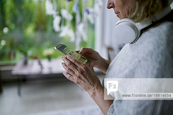 Senior woman text messaging and using smart phone at home
