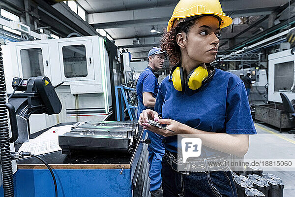 Maintenance engineer working in modern factory using robotics