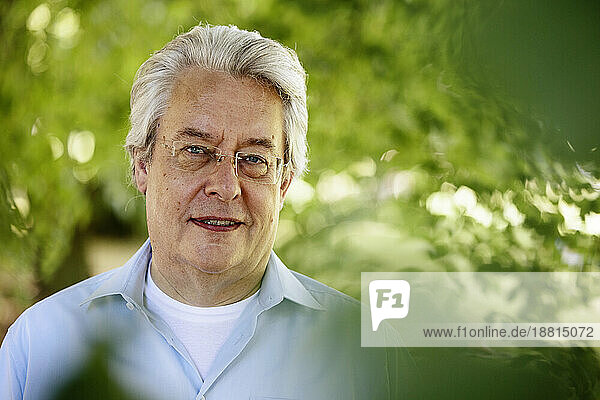 Senior man with gray hair smiling in park