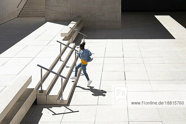 Woman moving up on stairs at sunny day