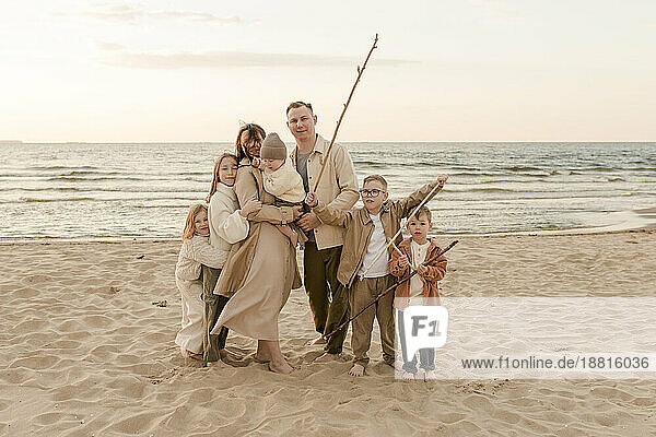 Glückliche Familie mit Stock am Strand