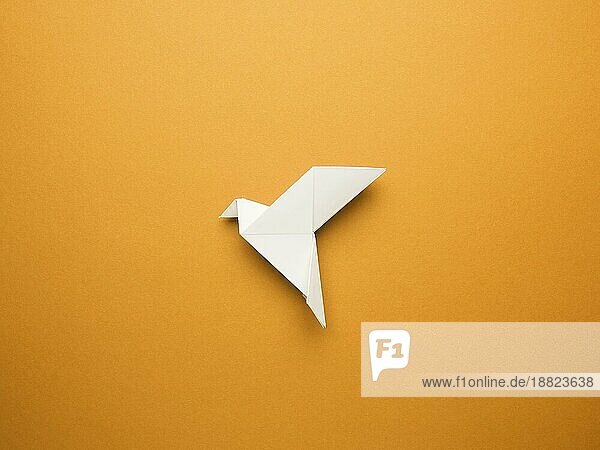 Origami Friedenstaube auf einem orangefarbenen Papier Hintergrund  Freiheit oder Frieden Konzept