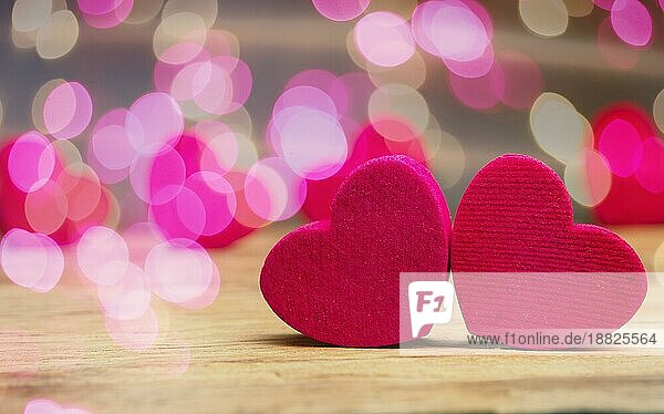 Kleine Holzherzen auf einem Holztisch mit schönen rosa Bokeh Effekte und Platz für Text  Valentinstag oder konzeptionelle Liebe Hintergrund
