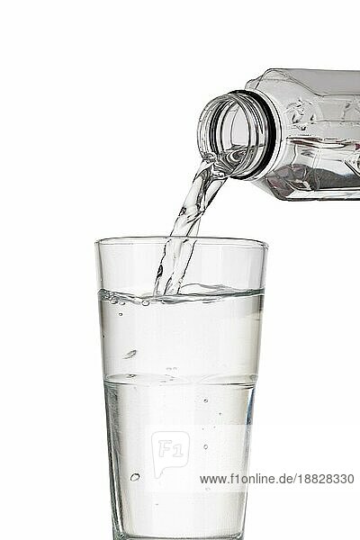 Wasserflasche gießt Wasser in Glas auf weißem Hintergrund