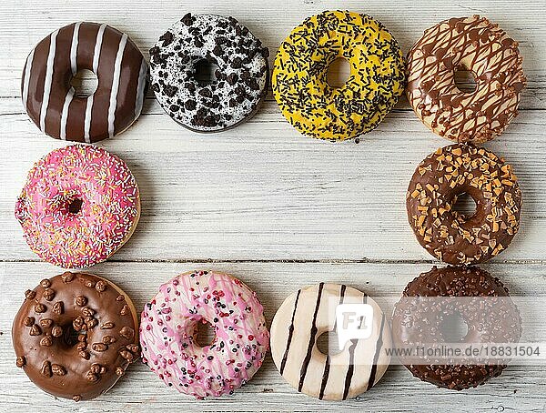 Draufsicht auf verschiedene Donuts auf einem hölzernen Hintergrund