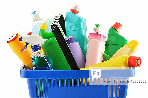 Einkaufskorb mit Waschmittelflaschen und chemischen Reinigungsmitteln vor weißem Hintergrund