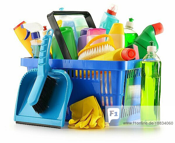 Einkaufskorb mit Waschmittelflaschen und chemischen Reinigungsmitteln vor weißem Hintergrund