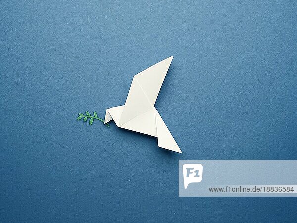 Weiße Origami Taube auf einem blaün Papierhintergrund  Frieden oder Freiheit Konzept  Papier Kunstwerk