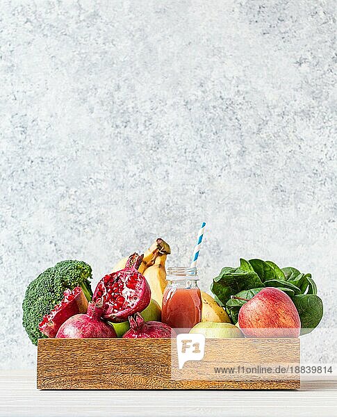 Obst  Gemüse  Gemüse in hölzernen Tablett und frischen Smoothie oder Saft in der Flasche mit Papier Stroh auf dem Tisch in der Nähe von weißen Wand  Detox  Diät  saubere Ernährung  vegetarisch  gesunde Ernährung Konzept  Platz für Text