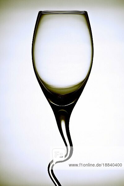 geschwungenes Weinglas kontrastreich vor weißem Hintergrund