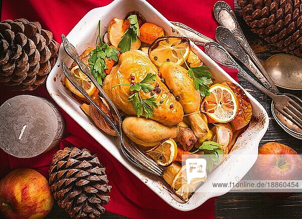 Gebratenes Huhn. Weihnachtsessen. Rustikaler Festtagstisch mit gebratenem Huhn  Gemüse  Äpfeln  dekoriert mit Kerzen  Vintage-Besteck. Weihnachten/Dankeschön-Essen. Festliches Abendessen. Ansicht von oben