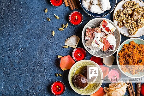 Indischer Diwali Feierhintergrund mit traditionellen Süßigkeiten Gulab Jamun  Karotten Halwa  Snacks mit Kerzen  Blumen. Assorted indischen Desserts. Feiertag Festtagstisch. Diwali Einstellung. Platz für Text