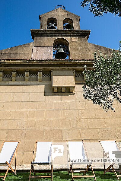 Liegestühle unter dem Glockengiebel mit drei Glocken einer Kirche in Donostia San Sebastian  Baskenland in Spanien