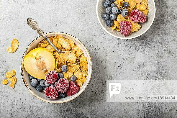Gesundes Frühstück Schüssel  Müsli  frisches Obst  Beeren auf dem Tisch. Saubere Ernährung  Diät-Konzept. Ansicht von oben. Gesunde Schüssel mit Müsli  Himbeeren  Heidelbeeren  Pflaume. Platz für Text. Selektiver Fokus
