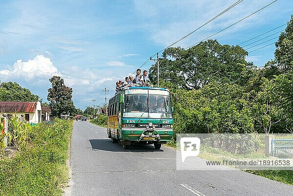 Transport von jungen Studenten  einige sitzen auf dem Dach des Busses  gesehen auf der Insel Samosir in der Provinz Nord Sumatra