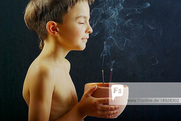 Junge mit Räucherstäbchen  Räucherstäbchen  Geruch  riechen  Aroma  Aromatherapie  Räucherschale  seitlich