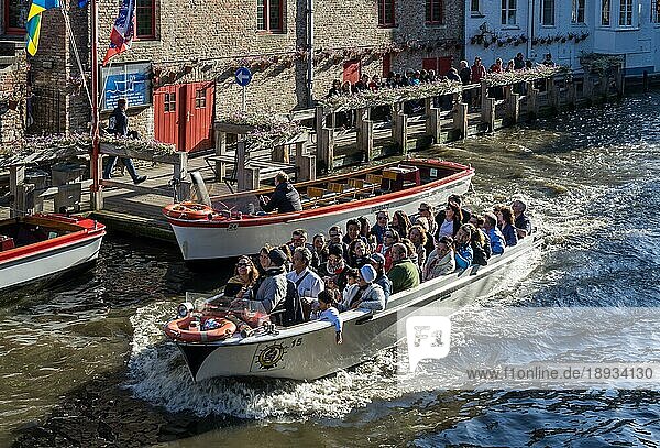 Tourist bei einer Bootsfahrt durch Brügge in Westflandern in Belgien