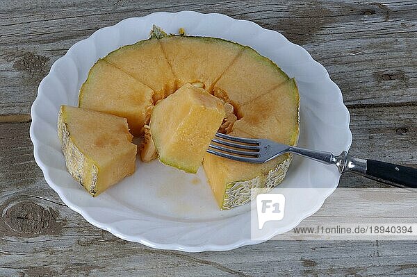 Cantaloupe-Melone auf Teller mit Gabel (Cucumis melo) (Cucurbitaceae)
