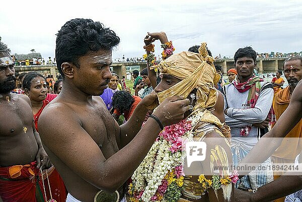 Ein Mann bindet ein Stück Stoff zum Verschließen des Mundes  Vaikasi Visakam Festival in Tiruchendur  Tamil Nadu  Südindien  Indien  Asien