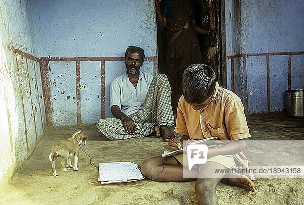 Ein Junge macht seine Hausaufgaben auf dem Sitzplatz in Courtalam Kutralam Kuttalam  Tamil Nadu  Südindien  Indien  Asien