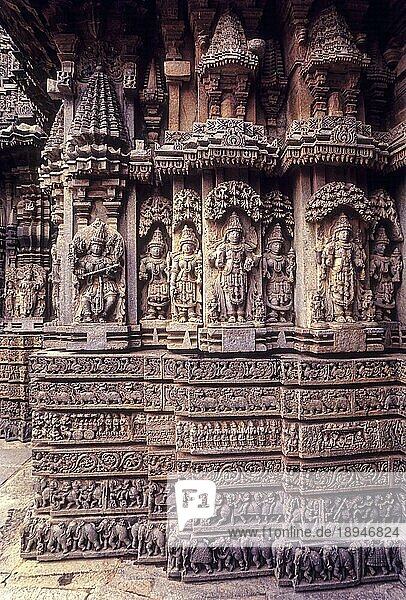 Venugopala  Keshava und Janardana mit ihren Konzerten und der Hälfte der Wandfläche mit den geschnitzten horizontalen Bindungen im Chennakesava-Tempel in Somanathapura Somnathpur  Karnataka  Südindien  Indien  Asien