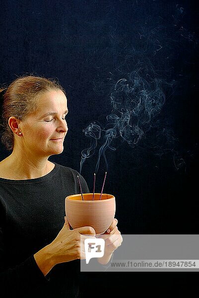 Frau mit Räucherstäbchen  Räucherstäbchen  Geruch  riechen  Aroma  Aromatherapie  Räucherschale