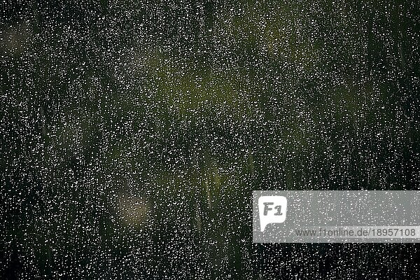 Regentropfen hängen an einer Fensterscheibe. Berlin  27.06.2023.  Berlin  Deutschland  Europa