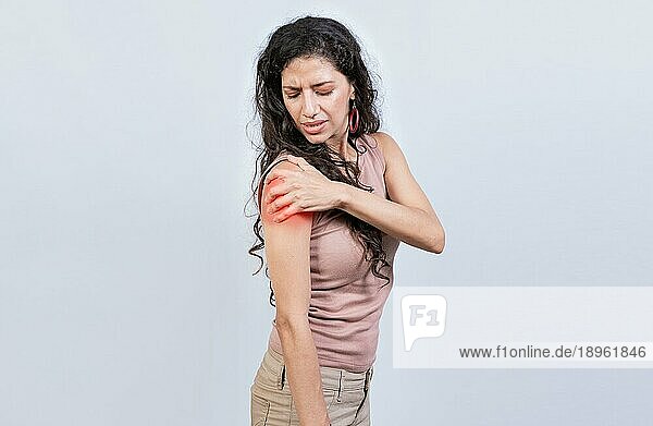 Frau mit Schulter und Armschmerzen auf isoliertem Hintergrund. Wunde junge Frau mit Armschmerzen isoliert. Frau leidet mit Arm Schmerzen
