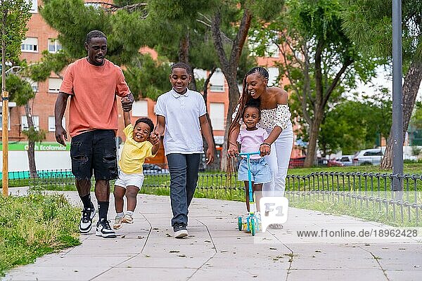 Afrikanische schwarze ethnische Familie mit Kindern auf dem Spielplatz  die sich im Stadtpark vergnügen