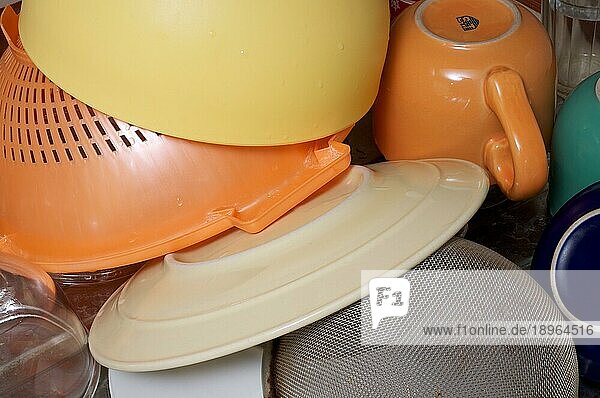 Gewaschene farbige Teller  Schüsseln  Tassen und Gläser  mit einem Sieb  das in der Nähe des Spülbeckens trocknet