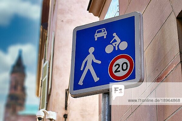 Blaues Geschwindigkeitsbegrenzungsschild 20km h Home Zone mit Auto  Fahrrad und Fußgänger auf einer französischen Straße