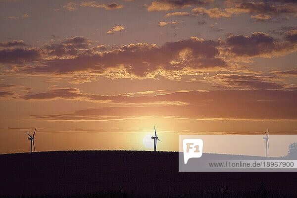Windmühlen Silhouetten auf einem Hügel in einem schönen Sonnenuntergang mit dramatischen Himmel