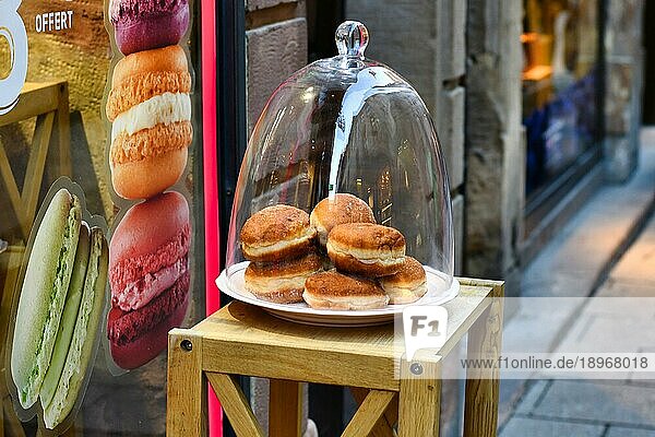 Berliner Pfannkuchen  ein traditionelles deutsches Dessert  das einem Krapfen ohne Loch ähnelt  bedeckt von einer Cloche vor einer Bäckerei  Straßburg  Frankreich  Europa