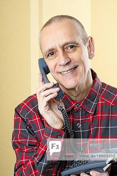 Fröhlicher Mann lächelt und spricht am Telefon