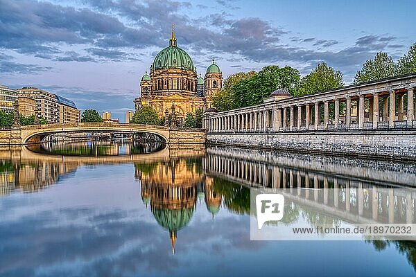 Der Berliner Dom in der Abenddämmerung mit einer Spiegelung in der Spree