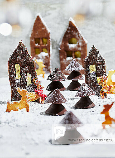 Gingerbread house biscuits with chocolate trees in the snow