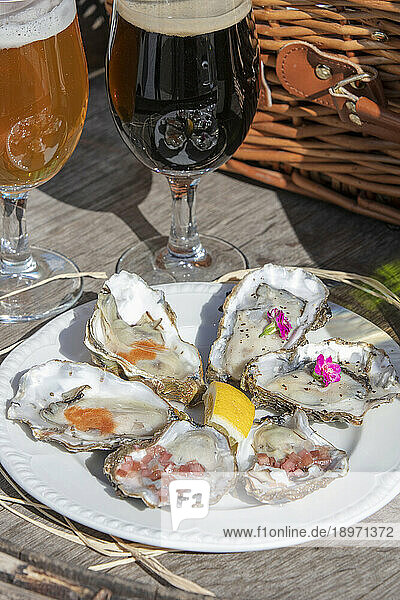 Freshly opened oysters with shallots  lemon  and sauce  served with beer